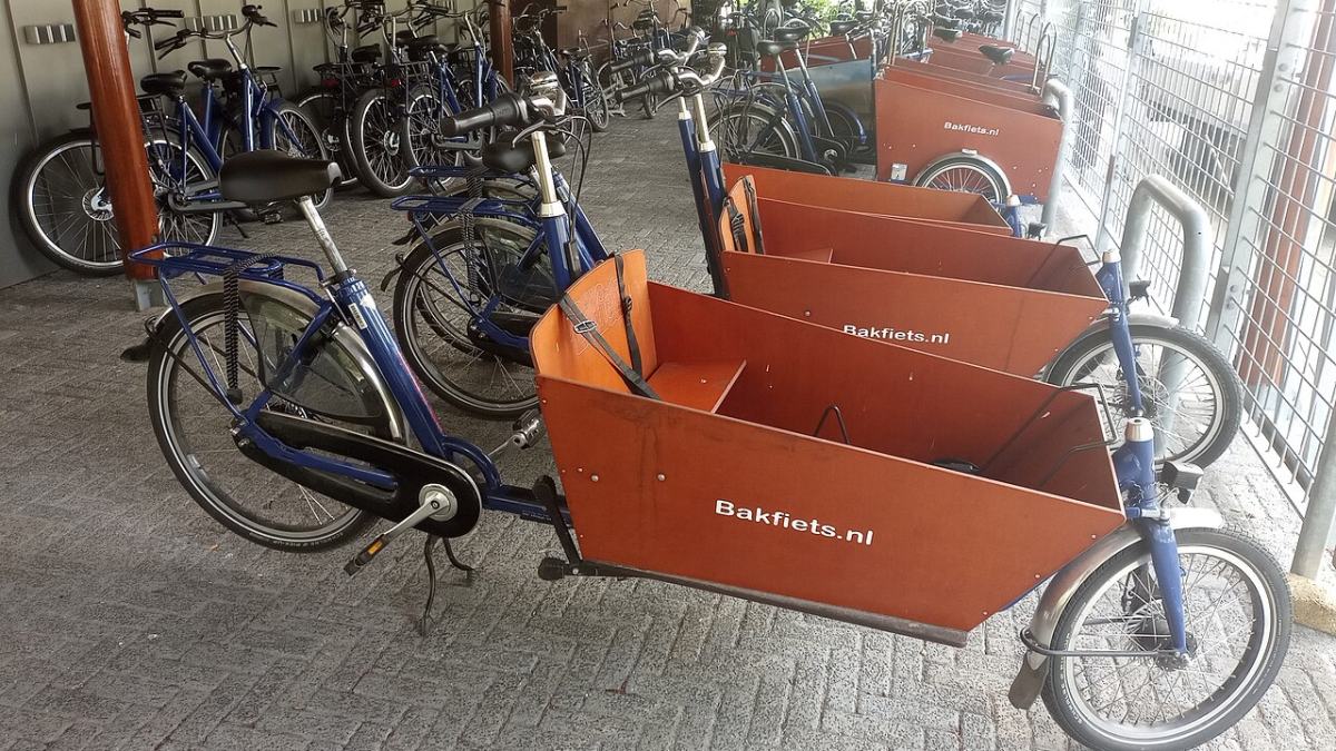 Bakfietsen met laadbak geparkeerd in een stalling